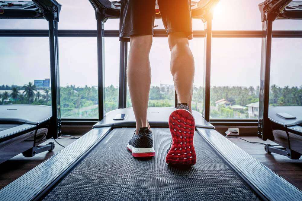 Male legs on a treadmill.
